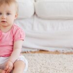 baby sitting on floor in front of couch