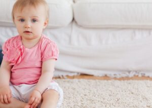 baby sitting on floor in front of couch