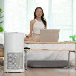 woman meditating in room with air purifier