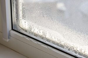 Drops of condensate and black mold on a substandard metal-plastic window. Plastic. Ecology